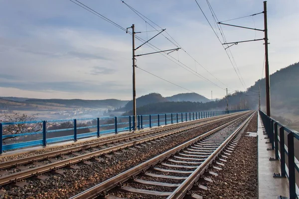 Nebliger Morgen auf der Eisenbahnbrücke. Eisenbahn. Schlafräume an der Brücke. — Stockfoto