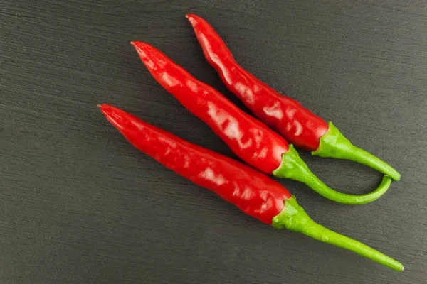 Red chilly pepper on wooden black background. Red hot chili peppers.  Domestic cultivation extra hot chilli burn. Growing chili peppers. Spicy seasoning food. Healthy spices. — Stock Photo, Image