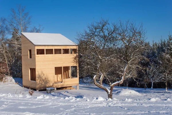 Schneebedeckter Standort ökologisches Haus. das Holzhaus im Wald. — Stockfoto