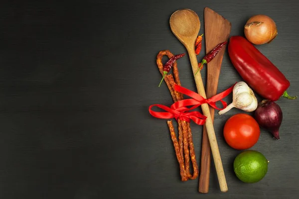 Cucharas de madera y verduras sobre una mesa negra. Preparación de alimentos. Decoración publicitaria del restaurante . — Foto de Stock