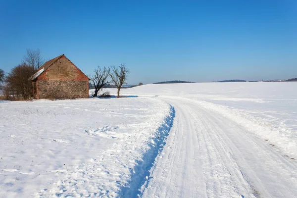 Alte verlassene Scheune im Winter. Schneebedeckte Landschaft. Landstraße im Winter. die Landschaft in der Tschechischen Republik. — Stockfoto