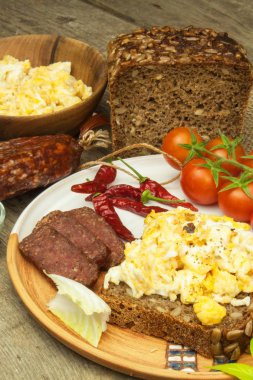 Ekmek ve salamlı omlet. Ahşap bir masa üzerinde yumurta kahvaltı. Sağlıklı gıda.