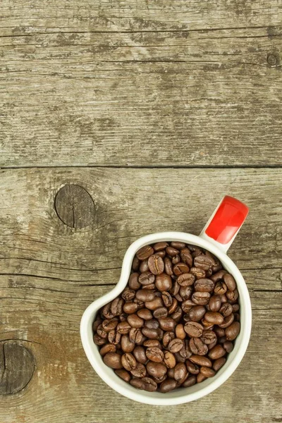 Tasse Kaffeebohnen auf einem alten Holztisch. Verkauf von Kaffee. Dekorationen für die Speisekarte. Kaffeestube. — Stockfoto