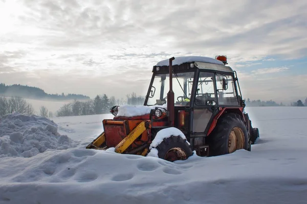 Старий трактор під снігом. Снігопади в транспорті. Заморожений дизельний двигун . — стокове фото