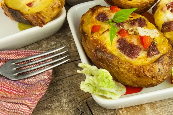 Pommes de terre farcies au four sur une table en bois. Une nourriture saine. Dîner aux devoirs . — Photo