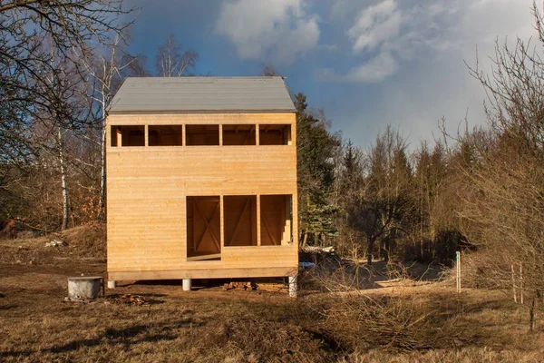 Lente op de bouw van ecologische gebouwen. Onvoltooide houten huis op de rand van het bos. Voorjaar weer in Tsjechië. — Stockfoto