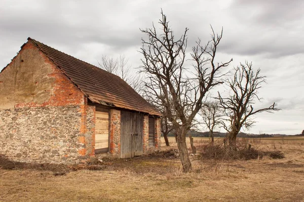 De oude schuur op het platteland. Agrarische gebouwen. Bewolkte hemel boven de boerderij. — Stockfoto