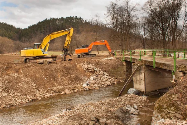 Flood adjustments river. Work on the riverbed. Excavator on the work to strengthen the shoreline of the river. — Stock Photo, Image