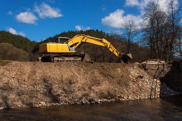 Excavator on the work to strengthen the shoreline of the river. — Stock Photo, Image