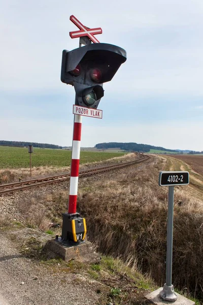 Attraversamento ferroviario nella Repubblica ceca. Strada che attraversa i binari. La scritta "ATTENZIONE TRENO ". — Foto Stock