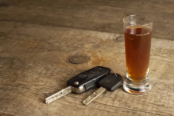 Alcohol and driving. Danger on the roads. Alcoholic behind the wheel. Car keys on the bar. — Stock Photo, Image