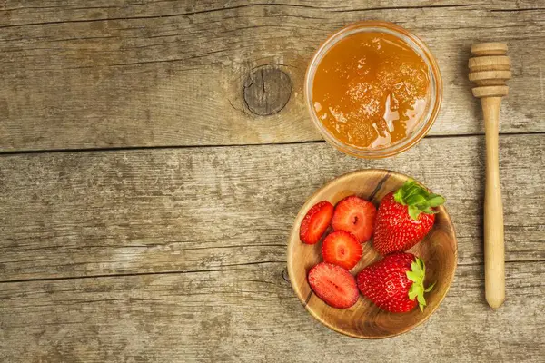 Binas honung och färska jordgubbar. Söt mat. Försäljning av honung. — Stockfoto