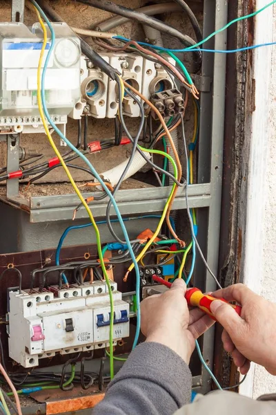 Reparação de aparelhagem eléctrica antiga. Um eletricista substitui antigos dispositivos de fiação elétrica . — Fotografia de Stock