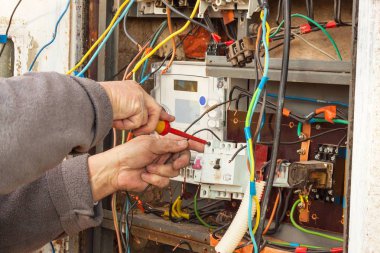 Eski bir evde elektrik dağıtım tamiri. Adam geçiş panosunu tamir.