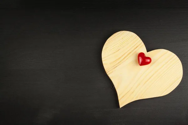 Corazón de madera sobre fondo negro. Deseo el Día de San Valentín. Lugar para el texto . — Foto de Stock