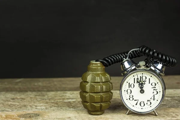 Grenade and old alarm clock. Timed bomb. The concept of terrorism. — Stock Photo, Image