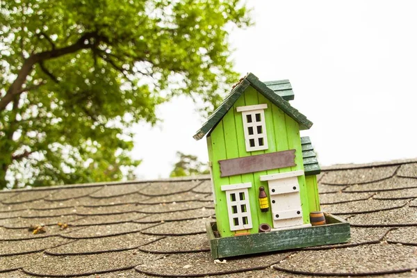 Modelo de madera de una casa familiar en el techo de asfalto. Venta de hipotecas para la construcción de una casa . — Foto de Stock