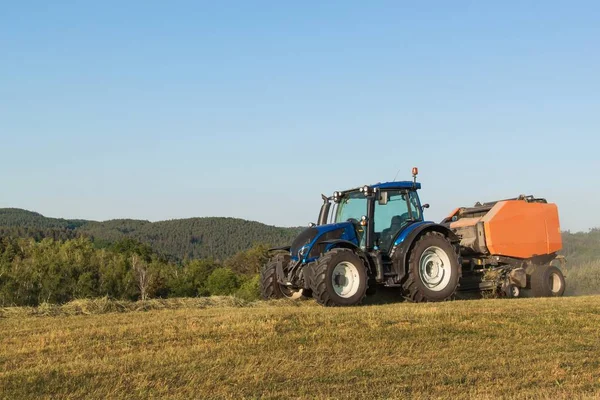 Blauer Traktor auf der Weide.. landwirtschaftliche Arbeit auf dem Bauernhof in der Tschechischen Republik. — Stockfoto