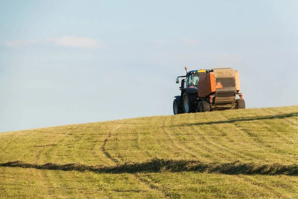Traktor biru di padang rumput.. Pekerjaan pertanian di pertanian di Republik Ceko . — Stok Foto