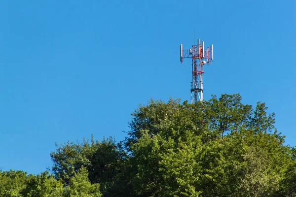 Technology on the top of the telecommunication GSM. Masts for mobile phone signal. Tower with antennas of cellular communication on the background of blue sky.