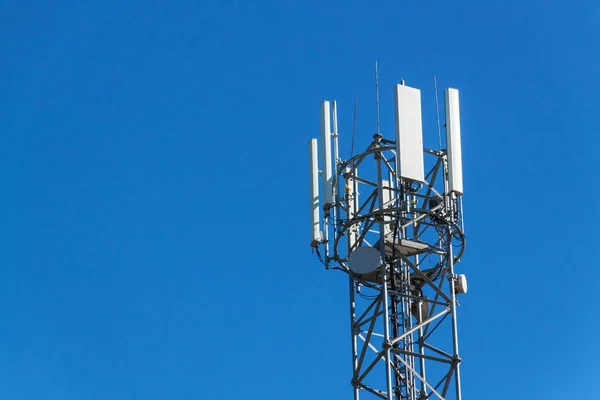 Teknoloji telekomünikasyon direkleri Gsm. cep telefonu sinyal için üst kısmında. Mavi gökyüzü arka planda hücresel iletişim antenler ile kule.