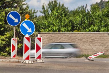 Yolda dolambaçlı yol. Trafik işaretleri. Asfalt yol onarımı.