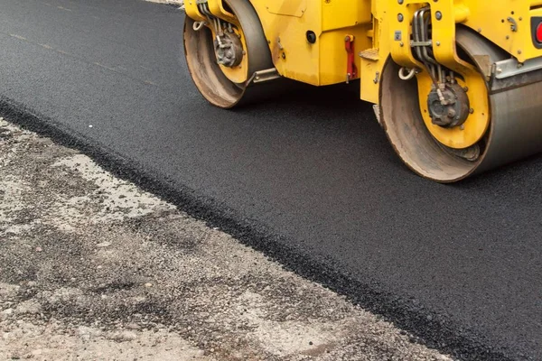 Yeni asfalt yol. Yol asfaltı çalışıyor. İnşaat çalışmaları.