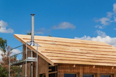 Paslanmaz çelik baca ekolojik bir ev bina. Enerji tasarrufu sağlayan ahşap ev. Cottage forest yakınındaki inşaatı.