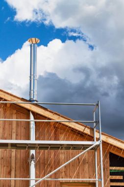 Paslanmaz çelik baca ekolojik bir ev bina. Enerji tasarrufu sağlayan ahşap ev. Cottage forest yakınındaki inşaatı.