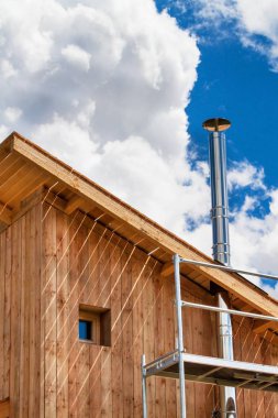 Paslanmaz çelik baca ekolojik bir ev bina. Enerji tasarrufu sağlayan ahşap ev. Cottage forest yakınındaki inşaatı.