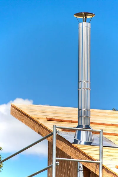 Stainless steel chimney on the building of an ecological home. Energy-saving wooden house. Construction of the cottage near the forest. — Stock Photo, Image