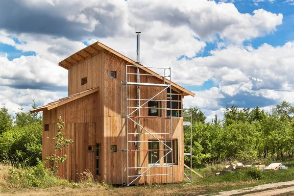 Cheminée en acier inoxydable sur la construction d'une maison écologique. Maison en bois économe en énergie. Construction du chalet près de la forêt . — Photo