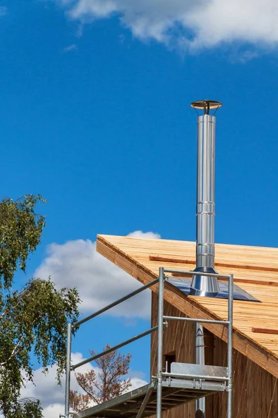 Paslanmaz çelik baca ekolojik bir ev bina. Enerji tasarrufu sağlayan ahşap ev. Cottage forest yakınındaki inşaatı.