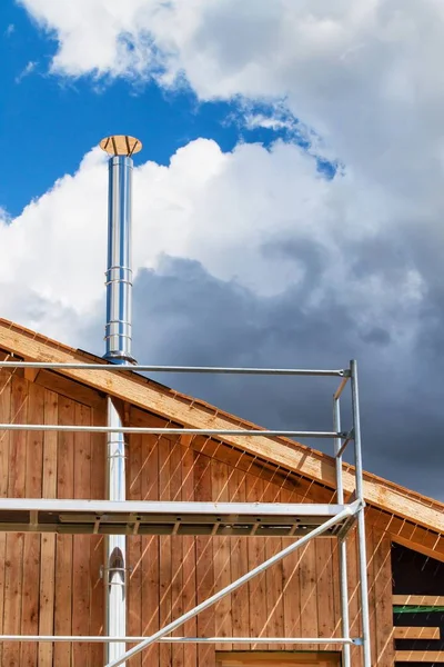 Paslanmaz çelik baca ekolojik bir ev bina. Enerji tasarrufu sağlayan ahşap ev. Cottage forest yakınındaki inşaatı.