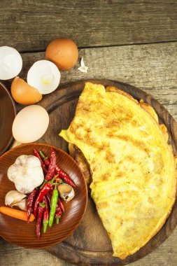 Ahşap oyun tahtası lezzetli dolma omlet. Kızarmış yumurta omlet kiraz domates, sarımsak ve biber ile. Besleyici Kahvaltı.