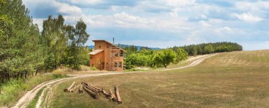 Ormanın yakınında yeşil bir ev inşa panoramik görünüm. Müstakil bir ev inşaatı. Ahşap yapılar.