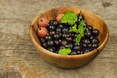 Ahşap bir masa üzerinde taze Siyah frenk üzümü. Sağlıklı meyve, vitaminler ve antioksidanlar dolu. Sağlıklı gıda.