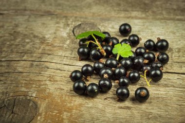 Ahşap bir masa üzerinde taze Siyah frenk üzümü. Sağlıklı meyve, vitaminler ve antioksidanlar dolu. Sağlıklı gıda.