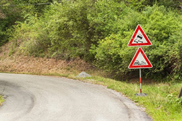 在湿滑路面上的路警告标志。在道路上洒了的砾石。在捷克共和国的乡间小路. — 图库照片