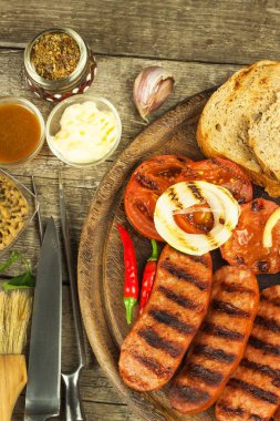 Hardal ahşap kesme tahtası üzerinde ızgara sosis. Yaz Barbekü partisi. Yağlı yemek.