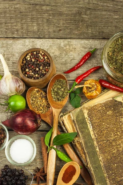 Livro velho de receitas de cozinha. Fundo culinário e livro de receitas com vários temperos em mesa de madeira . — Fotografia de Stock