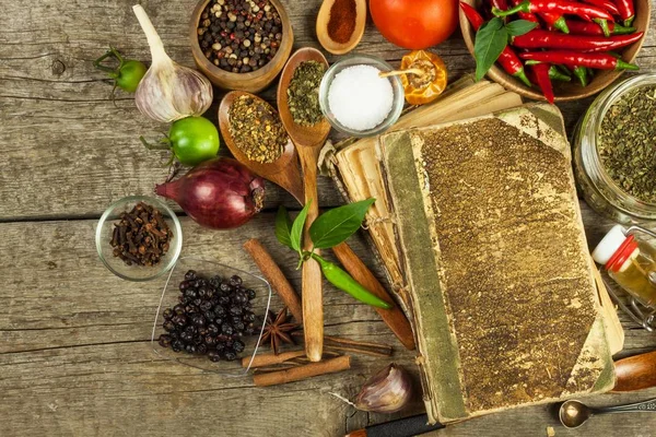 Oud boek van koken recepten. Culinaire achtergrond en recept boek met verschillende kruiden op houten tafel. — Stockfoto