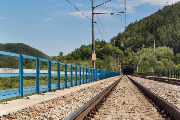 Wejście do tunelu, na moście kolejowym. Podróż pociągiem w całej Europie. — Zdjęcie stockowe