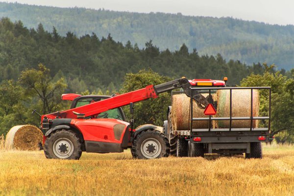 Телескопический коллектор соломы на поле в Чешской Республике. Работа на сельскохозяйственной ферме. Сбор соломенных тюков
.