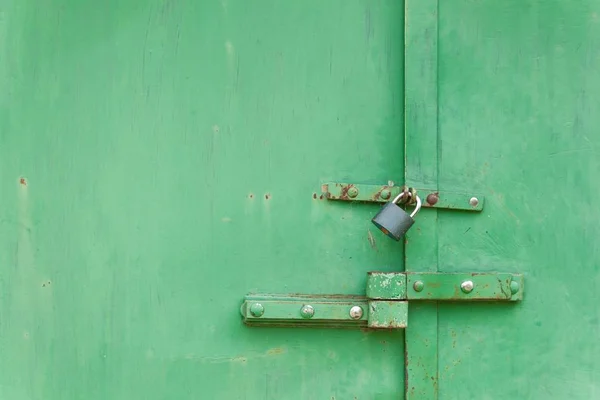 Old iron gate with lock. Locked sheet metal doors. Place for your text. Home security concept. — Stock Photo, Image