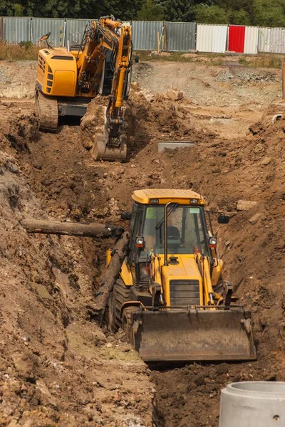 新的污水收集系统建设。推土机挖战壕中的下水管道。建筑工程. — 图库照片