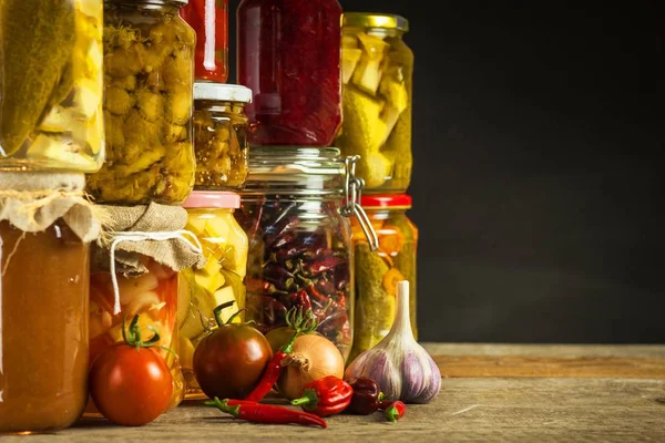 Gläser mit verschiedenen eingelegten Gemüse. Möhren, Feldknoblauch, Petersilie im Glas. Konserven. Fermentiertes vegetarisches Ernährungskonzept. — Stockfoto