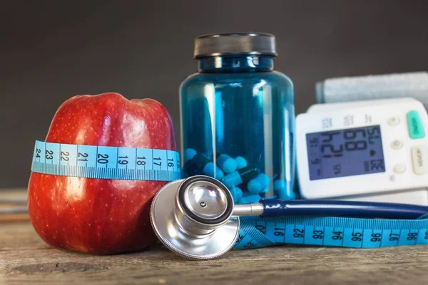 Maçã vermelha com fita métrica para medir o comprimento. Tratamento da obesidade e diabetes, medição da pressão arterial . — Fotografia de Stock