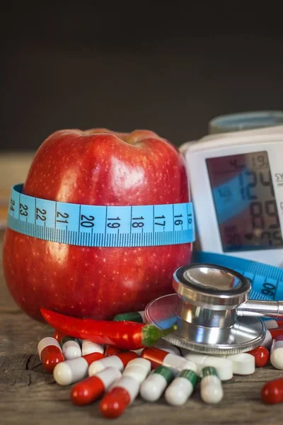 Manzana roja con cinta métrica para medir la longitud. Tratamiento de la obesidad y la diabetes, medición de la presión arterial . — Foto de Stock