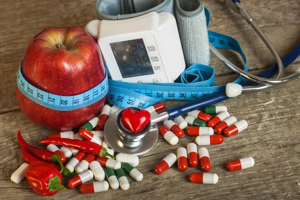 Roter Apfel mit Maßband zur Längenmessung. Behandlung von Fettleibigkeit und Diabetes, Blutdruckmessung. — Stockfoto